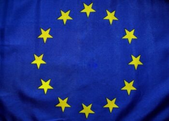 Bandera de la Unión Europea con fondo azul y un círculo de doce estrellas amarillas, símbolo de unidad y solidaridad entre los países miembros.