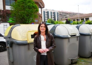 Laura Velasco, portavoz de VOX en el Ayuntamiento de Santander, frente a varios contenedores de basura, denunciando el impacto de la Ley de Residuos y Suelos Contaminados en el incremento del coste del servicio de basuras.