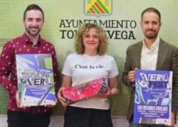 Presentación del evento Vermú Fest en el Ayuntamiento de Torrelavega, con tres representantes municipales posando con carteles promocionales del festival que convierte a la ciudad en capital de la música cántabra