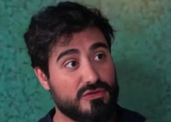 Imagen de Alvise Pérez con gesto serio frente a un fondo verde, en el contexto de la apertura de diligencias previas por parte del Tribunal Supremo por presunta financiación ilegal.