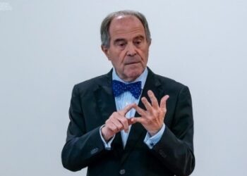 El doctor Alfonso López Borgoñoz durante una charla, gesticulando mientras argumenta a favor del uso del dinero en efectivo, en el contexto de su defensa de las libertades individuales y la privacidad financiera.