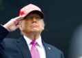 Donald Trump saluda militarmente con una gorra roja de "Make America Great Again", durante un acto público, en el contexto de sus declaraciones sobre un nuevo acuerdo comercial con Europa.